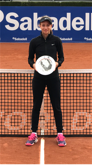 La tenista nuciera Lucía Llinares posa con su trofeo de subcampeona en la pista cetral del Conde Godó