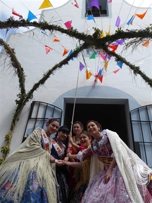 Reina y damas de las fiestas repicando la campana de la ermita