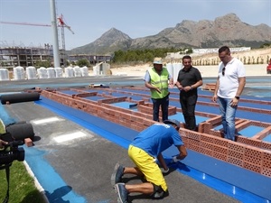 Ernesto Romano Giner, de Mondo Ibérica mostrando la instalación de la superficie de la Pista de Atletismo al concejal Sergio Villalba y a Bernabé Cano, alcalde de La Nucia