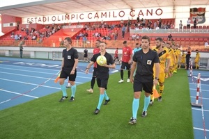 Los dos equipos saltando al césped del Estadi Olímpic Camilo Cano