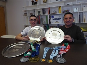 El nadador Miguel Bou muestra todas sus medallas y trofeos de 2019 junto a Bernabé Cano, alcalde de La Nucía