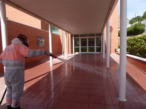 Limpiando y desinfectando rampa de entrada al Colegio Sant Rafel