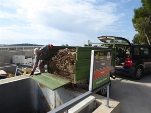 Un usuario del Ecoparque deposita restos de poda en el contenedor indicado