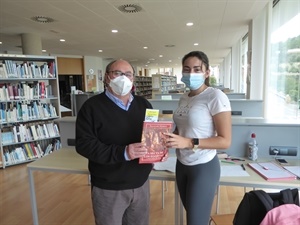 Una usuaria de la Biblioteca Municipal recibe un libro de manos de Pedro Lloret, concejal de Cutlura