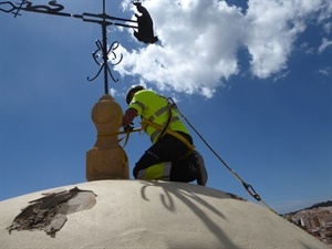 Operario asegurando la base de la veleta del campanario