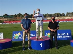 El atleta Domingo Ramón, doble diploma olímpico, en el podium en su pequeño homenaje junto a Raúl Chapado,pte. RFEA y Bernabé Cano, alcalde de La Nucía